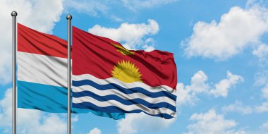 Lüksemburg ve Kiribati bayrağı birlikte beyaz bulutlu mavi gökyüzüne karşı rüzgarda sallayarak. Diplomasi kavramı, uluslararası ilişkiler.