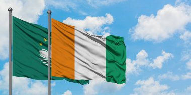 Macao ve Fildişi Sahili bayrağı birlikte beyaz bulutlu mavi gökyüzüne karşı rüzgarda sallayarak. Diplomasi kavramı, uluslararası ilişkiler.