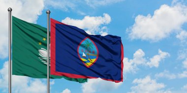 Macao ve Guam bayrağı birlikte beyaz bulutlu mavi gökyüzüne karşı rüzgarda sallayarak. Diplomasi kavramı, uluslararası ilişkiler.