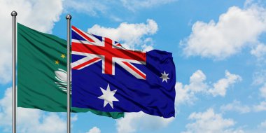 Macao ve Heard Adası ve Mcdonald Adaları bayrağı birlikte beyaz bulutlu mavi gökyüzüne karşı rüzgarda sallayarak. Diplomasi kavramı, uluslararası ilişkiler.