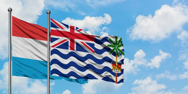 卢森堡和英属印度洋地区国旗在风中飘扬，白云蓝天相聚。外交概念、国际关系. — 图库照片