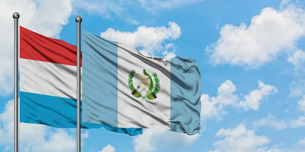 Люксембург і Гватемала прапор розмахуючи в вітру проти білого хмарного синього неба разом. Концепція дипломатії, міжнародні відносини. — стокове фото