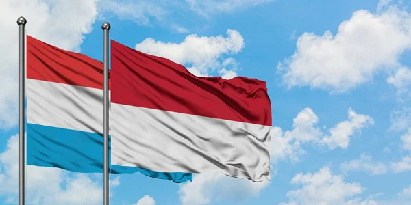 Luksemburg i Indonezja Flaga Macha w wiatr przed białym zachmurzone błękitne niebo razem. Koncepcja dyplomacji, stosunki międzynarodowe. — Zdjęcie stockowe