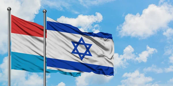Люксембург і Ізраїль прапор розмахуючи в вітру проти білого хмарного синього неба разом. Концепція дипломатії, міжнародні відносини. — стокове фото