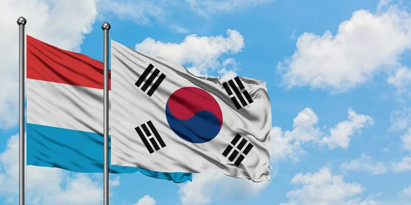 Lüksemburg ve Güney Kore bayrağı birlikte beyaz bulutlu mavi gökyüzüne karşı rüzgarsal sallayarak. Diplomasi kavramı, uluslararası ilişkiler. — Stok fotoğraf