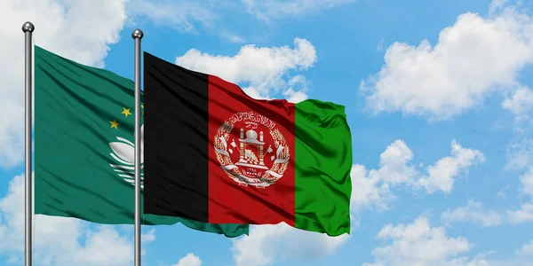 Bandera de Macao y Afganistán ondeando en el viento contra el cielo azul nublado blanco juntos. Concepto diplomático, relaciones internacionales . — Foto de Stock