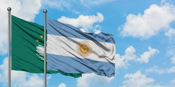 Bandera de Macao y Argentina ondeando en el viento contra el cielo azul nublado blanco juntos. Concepto diplomático, relaciones internacionales . — Foto de Stock