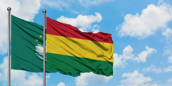 Bandera de Macao y Bolivia ondeando en el viento contra el cielo azul nublado blanco juntos. Concepto diplomático, relaciones internacionales . — Foto de Stock