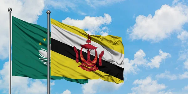Macao and Brunei flag waving in the wind against white cloudy blue sky together. Diplomacy concept, international relations.