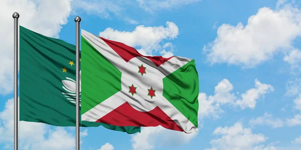 Macao and Burundi flag waving in the wind against white cloudy blue sky together. Diplomacy concept, international relations.