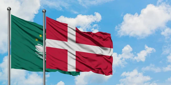 Macao a Dánská vlajka mávali ve větru proti bíle zatažené modré obloze. Diplomacie, mezinárodní vztahy. — Stock fotografie