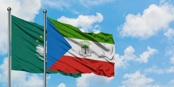 마카오와 적도 기니 깃발이 하얀 흐린 푸른 하늘을 배경으로 바람에 흔들리고 있습니다. 외교 개념, 국제 관계. — 스톡 사진