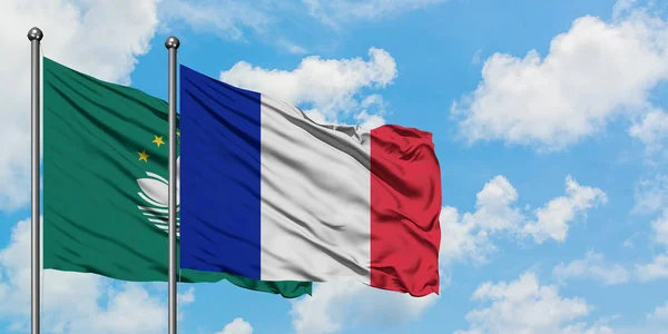 Bandera de Macao y Francia ondeando en el viento contra el cielo azul nublado blanco juntos. Concepto diplomático, relaciones internacionales . — Foto de Stock