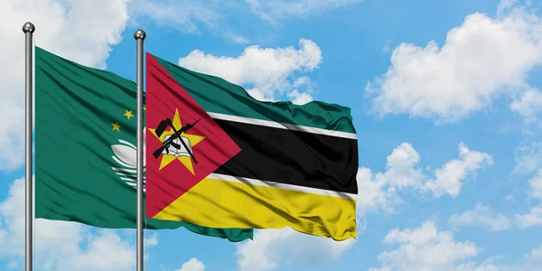 澳门和莫桑比克国旗在风中飘扬，白云蓝天相聚。外交概念、国际关系. — 图库照片