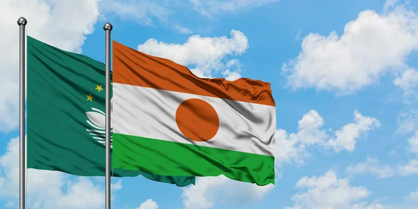 Macao and Niger flag waving in the wind against white cloudy blue sky together. Diplomacy concept, international relations.