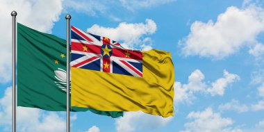 Macao ve Niue bayrağı birlikte beyaz bulutlu mavi gökyüzüne karşı rüzgarda sallayarak. Diplomasi kavramı, uluslararası ilişkiler.