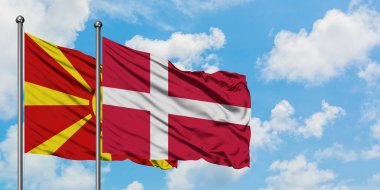 Makedonya ve Danimarka bayrağı birlikte beyaz bulutlu mavi gökyüzüne karşı rüzgarda sallayarak. Diplomasi kavramı, uluslararası ilişkiler.