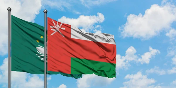 Bandera de Macao y Omán ondeando en el viento contra el cielo azul nublado blanco juntos. Concepto diplomático, relaciones internacionales . — Foto de Stock