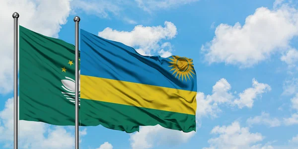 Macao and Rwanda flag waving in the wind against white cloudy blue sky together. Diplomacy concept, international relations.