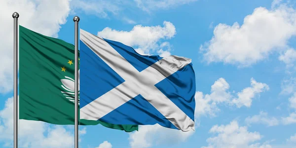 Macao and Scotland flag waving in the wind against white cloudy blue sky together. Diplomacy concept, international relations.