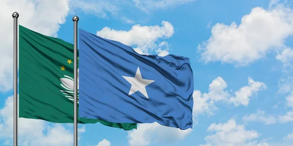 Bandera de Macao y Somalia ondeando en el viento contra el cielo azul nublado blanco juntos. Concepto diplomático, relaciones internacionales . — Foto de Stock