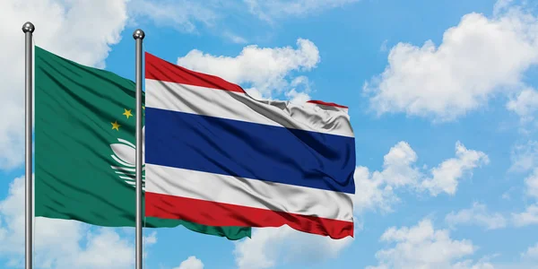 Macao and Thailand flag waving in the wind against white cloudy blue sky together. Diplomacy concept, international relations.