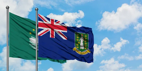 Bandera de Macao e Islas Vírgenes Británicas ondeando en el viento contra el cielo azul nublado blanco juntos. Concepto diplomático, relaciones internacionales . — Foto de Stock