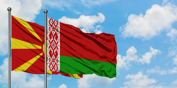 Bandera de Macedonia y Bielorrusia ondeando en el viento contra el cielo azul nublado blanco juntos. Concepto diplomático, relaciones internacionales . — Foto de Stock
