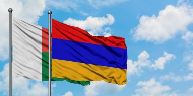 Madagaskar ve Ermenistan bayrağı birlikte beyaz bulutlu mavi gökyüzüne karşı rüzgarsal sallayarak. Diplomasi kavramı, uluslararası ilişkiler.