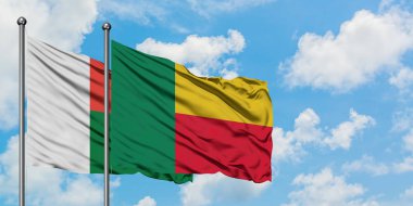 Madagaskar ve Benin bayrağı birlikte beyaz bulutlu mavi gökyüzüne karşı rüzgarda sallayarak. Diplomasi kavramı, uluslararası ilişkiler.
