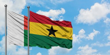 Madagaskar ve Gana bayrağı birlikte beyaz bulutlu mavi gökyüzüne karşı rüzgarda sallayarak. Diplomasi kavramı, uluslararası ilişkiler.