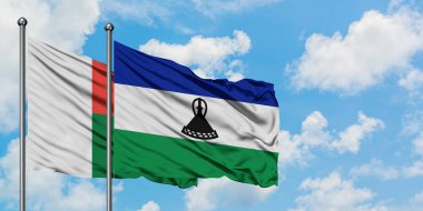 Madagaskar ve Lesotho bayrağı birlikte beyaz bulutlu mavi gökyüzüne karşı rüzgarda sallayarak. Diplomasi kavramı, uluslararası ilişkiler.