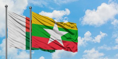 Madagaskar ve Myanmar bayrağı birlikte beyaz bulutlu mavi gökyüzüne karşı rüzgarda sallayarak. Diplomasi kavramı, uluslararası ilişkiler.