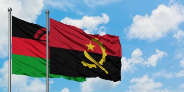 Malavi ve Angola bayrağı birlikte beyaz bulutlu mavi gökyüzüne karşı rüzgarda sallayarak. Diplomasi kavramı, uluslararası ilişkiler.