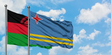 Malavi ve Aruba bayrağı birlikte beyaz bulutlu mavi gökyüzüne karşı rüzgarda sallayarak. Diplomasi kavramı, uluslararası ilişkiler.