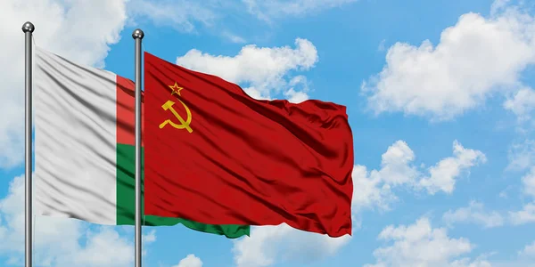 Madagascar and Soviet Union flag waving in the wind against white cloudy blue sky together. Diplomacy concept, international relations. — Stock Photo, Image