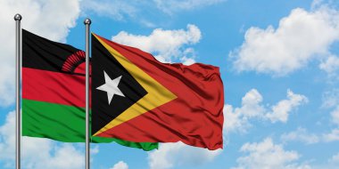 Malavi ve Doğu Timor bayrağı birlikte beyaz bulutlu mavi gökyüzüne karşı rüzgarda sallayarak. Diplomasi kavramı, uluslararası ilişkiler.