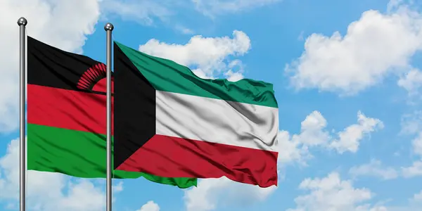 Bandera de Malawi y Kuwait ondeando en el viento contra el cielo azul nublado blanco juntos. Concepto diplomático, relaciones internacionales . — Foto de Stock