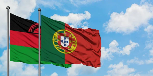 Флаг Малави и Португалии размахивает ветром против белого облачно-синего неба вместе. Концепция дипломатии, международные отношения . — стоковое фото