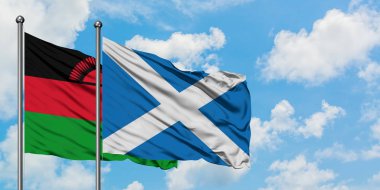 Malavi ve İskoçya bayrağı birlikte beyaz bulutlu mavi gökyüzüne karşı rüzgarda sallayarak. Diplomasi kavramı, uluslararası ilişkiler.