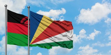 Malavi ve Seyşeller bayrak birlikte beyaz bulutlu mavi gökyüzüne karşı rüzgarda sallayarak. Diplomasi kavramı, uluslararası ilişkiler.