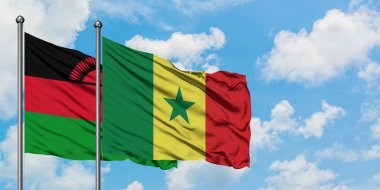Malavi ve Senegal bayrağı birlikte beyaz bulutlu mavi gökyüzüne karşı rüzgarda sallayarak. Diplomasi kavramı, uluslararası ilişkiler.