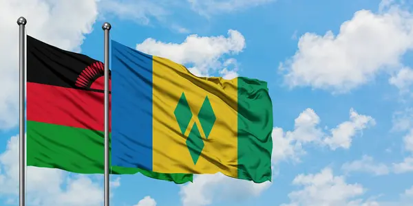 Malawi and Saint Vincent And The Grenadines flag waving in the wind against white cloudy blue sky together. Diplomacy concept, international relations. — Stock Photo, Image