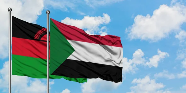 Bandera de Malawi y Sudán ondeando en el viento contra el cielo azul nublado blanco juntos. Concepto diplomático, relaciones internacionales . — Foto de Stock