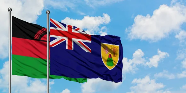 Bandera de Malawi y las Islas Turcas y Caicos ondeando en el viento contra el cielo azul nublado blanco juntos. Concepto diplomático, relaciones internacionales . — Foto de Stock
