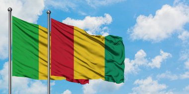Mali ve Gine bayrağı birlikte beyaz bulutlu mavi gökyüzüne karşı rüzgarda sallayarak. Diplomasi kavramı, uluslararası ilişkiler.