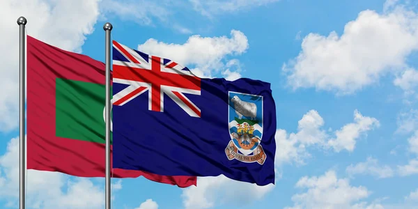 Bandera de Maldivas e Islas Malvinas ondeando en el viento contra el cielo azul nublado blanco juntos. Concepto diplomático, relaciones internacionales . — Foto de Stock