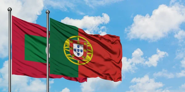 Maldivas y bandera de Portugal ondeando en el viento contra el cielo azul nublado blanco juntos. Concepto diplomático, relaciones internacionales . — Foto de Stock