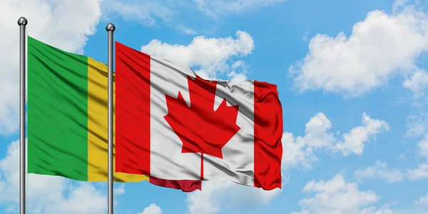 Bandera de Malí y Canadá ondeando en el viento contra el cielo azul nublado blanco juntos. Concepto diplomático, relaciones internacionales . — Foto de Stock
