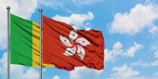 Bandera de Malí y Hong Kong ondeando en el viento contra el cielo azul nublado blanco juntos. Concepto diplomático, relaciones internacionales . —  Fotos de Stock